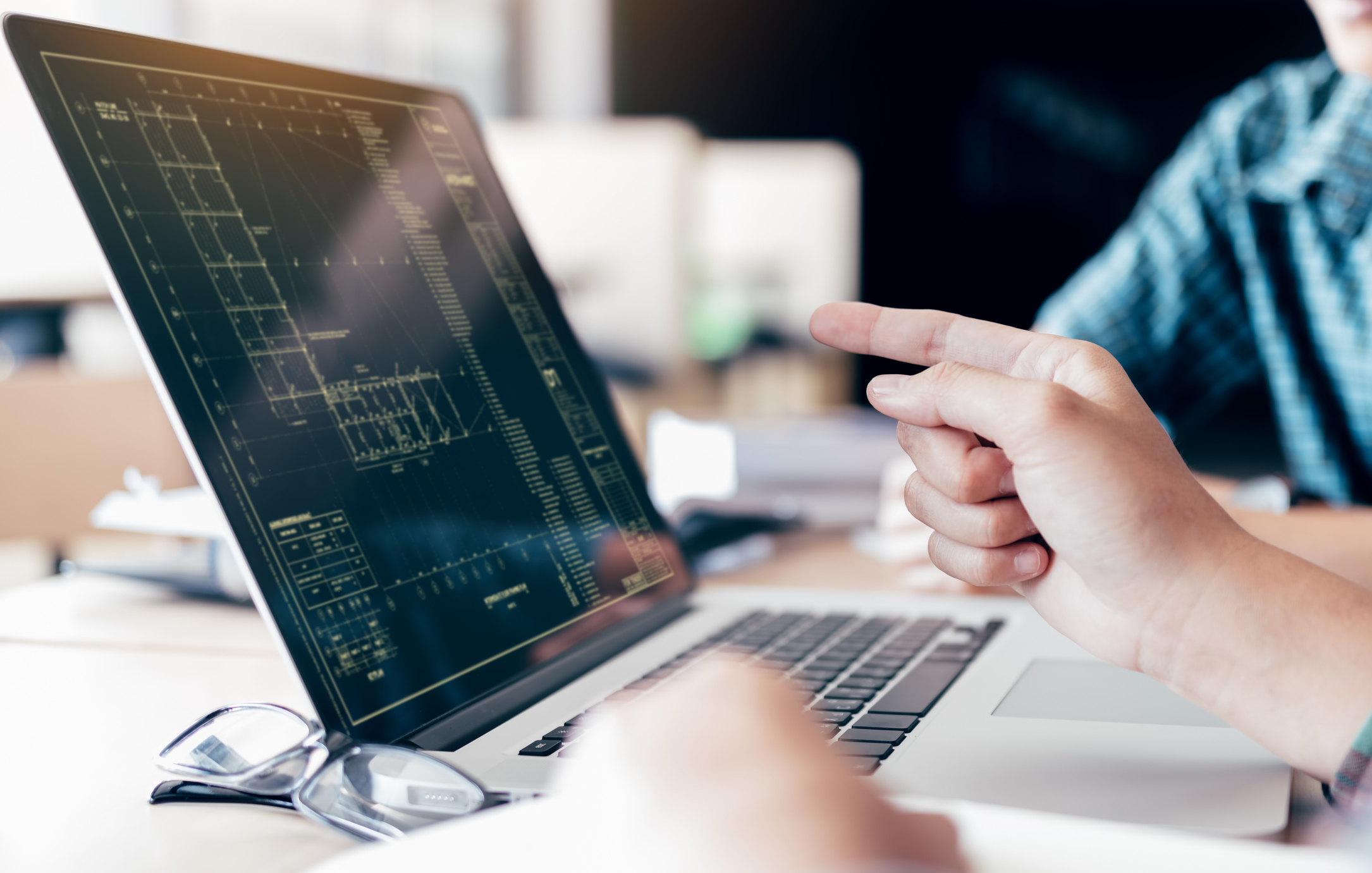 Изображение. Специалисты обсуждают чертеж на экране ноутбука