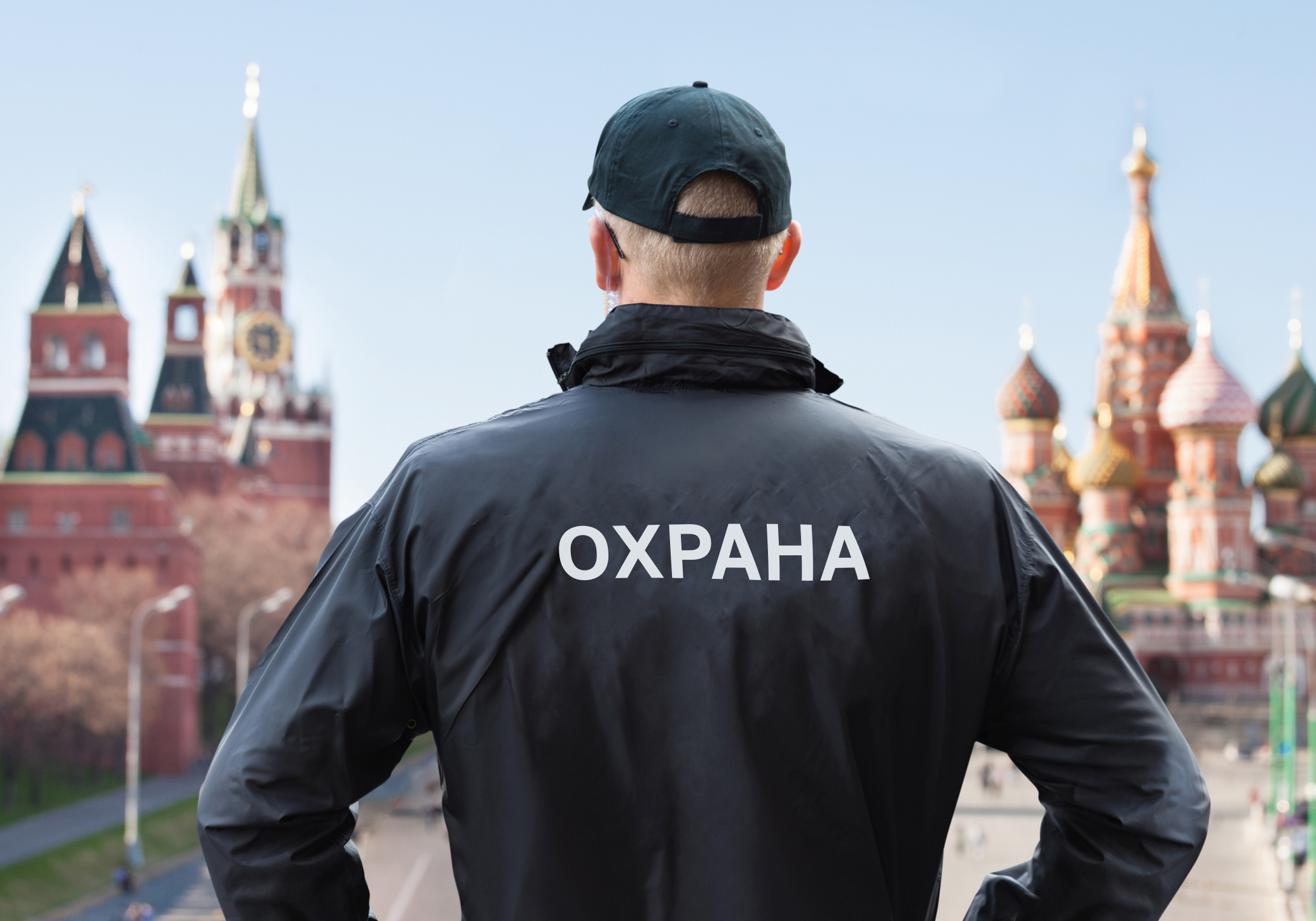 Изображение. Мужчина в куртке стоит спиной к кадру на фоне Красной площади.